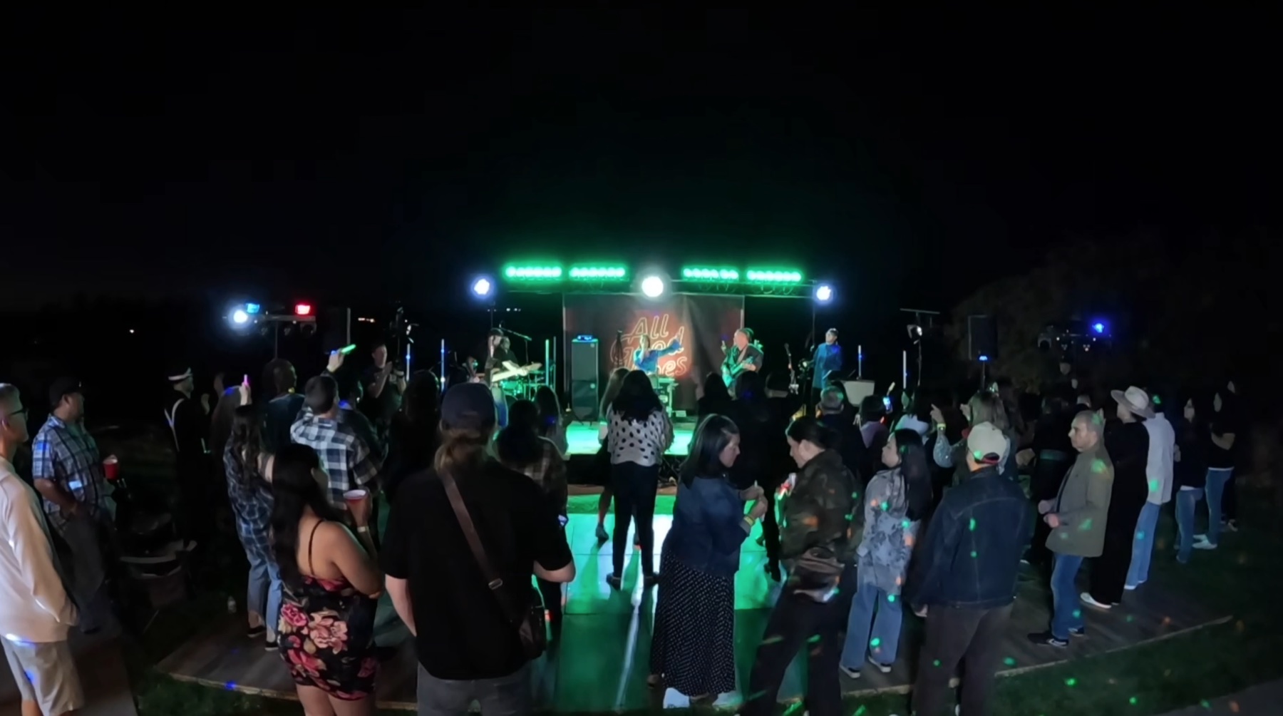Guests watching the live band under green stage lights