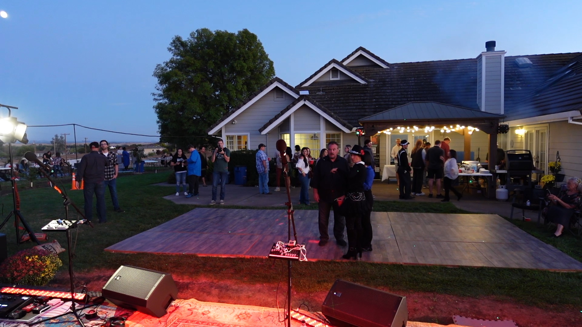 Guests gathering by the patio at twilight